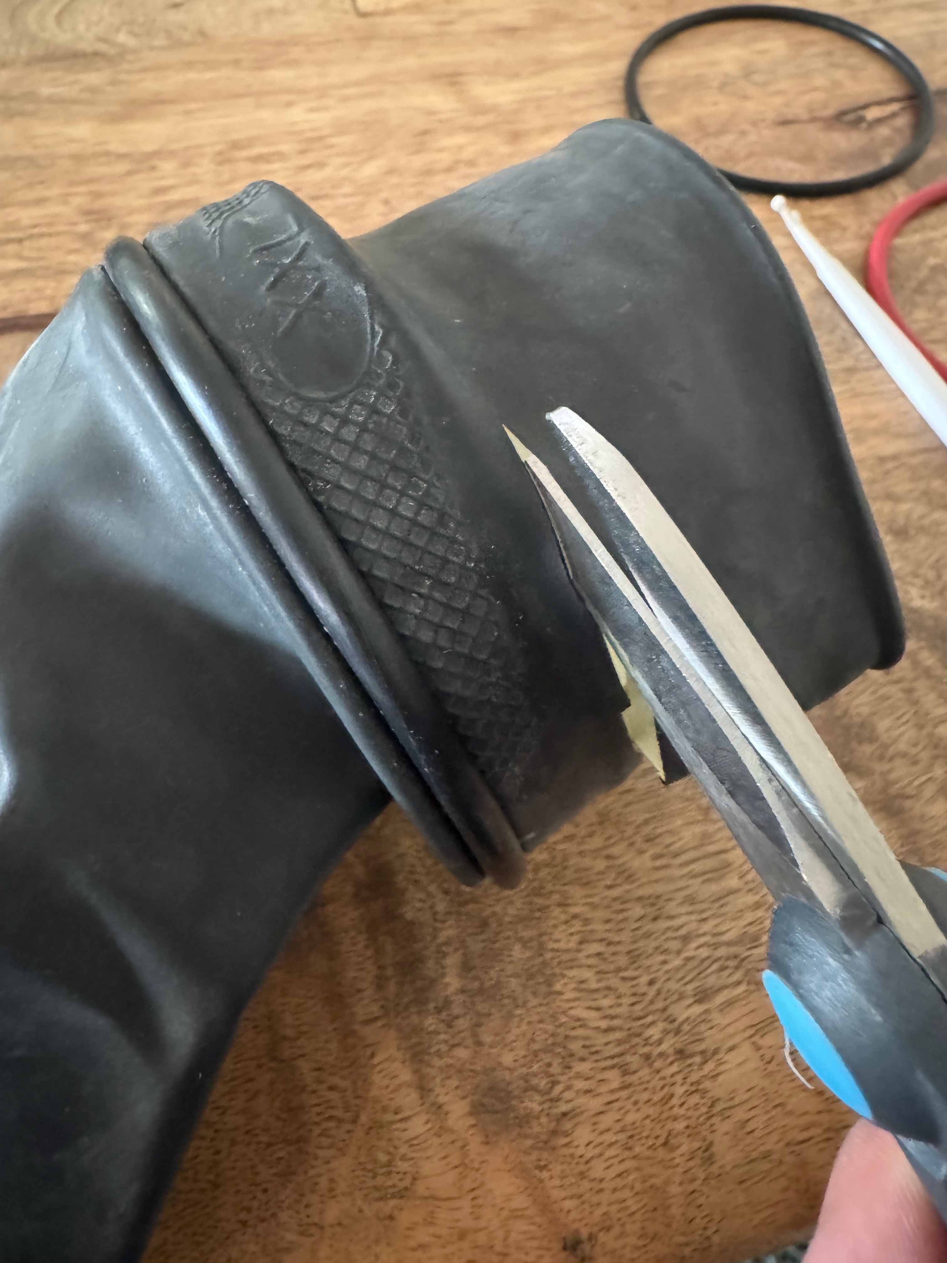 Scissors trimming the excess rubber cuff from the new glove on the Kubi ring