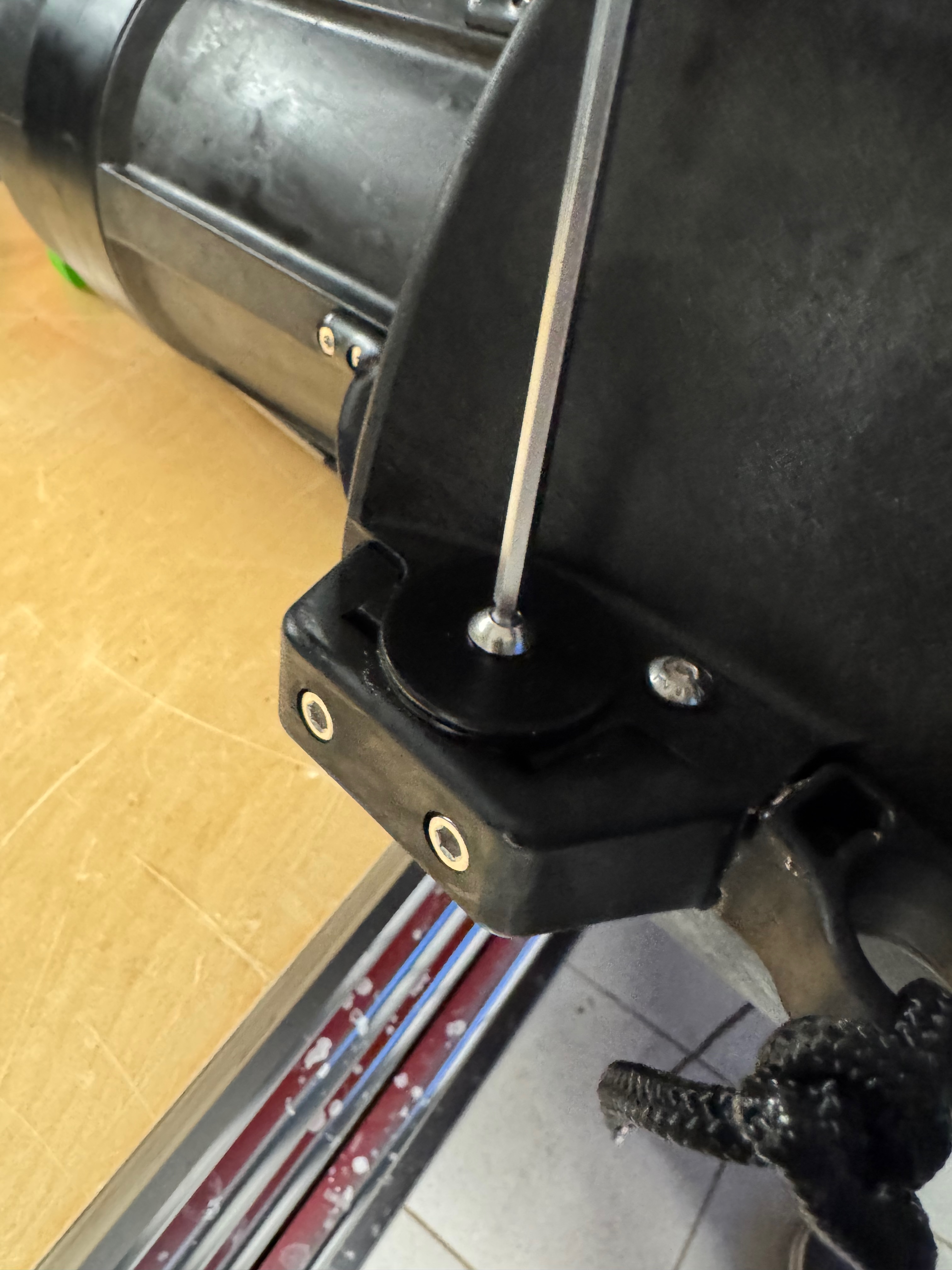 Unscrewing the weight disc bolt on the handle bracket with an allen key